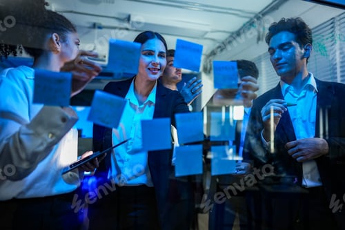 Preview: Diverse professional team engaged in a high energy brainstorming session, using sticky notes on a gl