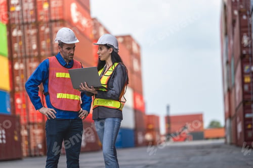 Preview: Two logistics workers man and woman discuss operations at a busy shipping container yard.