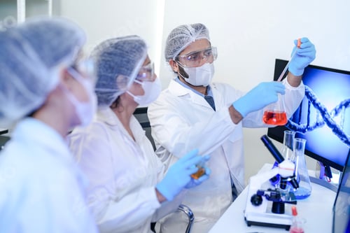 Preview: A focused scientist in protective gear using a microscope to analyze genetic samples with a digital