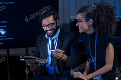 Preview: South Asian male cybersecurity analyst and Black female IT researcher with a bionic arm examine inci