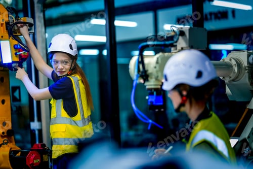 Preview: AI tech specialist in safety gear meticulously programming and configuring a complex robotic arm. Fo