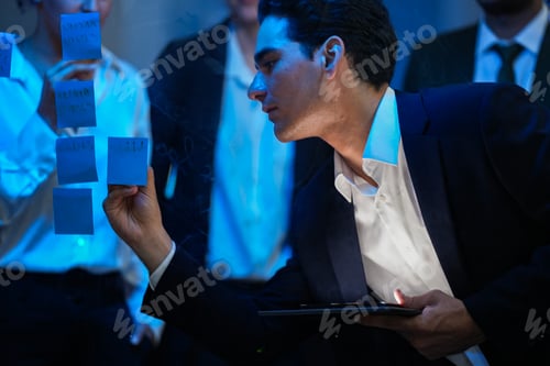 Preview: Diverse business team collaborating in a modern office at night. Professional specialist placing a s