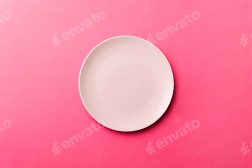 Preview: Top view of isolated of colored background empty round pink plate for food. Empty dish with space fo