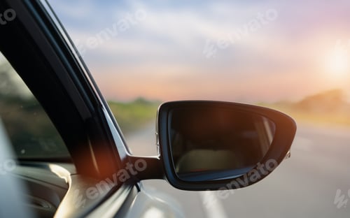 Preview: Car side mirror on highway road with sunset light for travel and transportation concept
