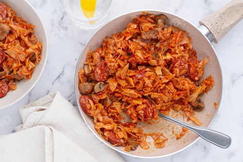 Preview: Bigos, Polish dish bigos, on the table, pan with stewed meat, with cabbage, chorizo sausages, mushro