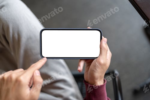 Preview: Top view of a man's hand holding white screen phone pointing a finger while sitting on chair in cafe