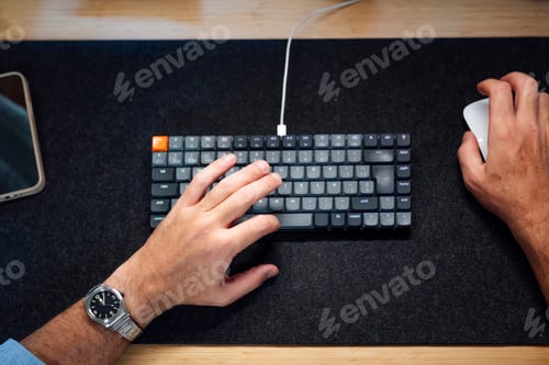 Preview: Hands typing on keyboard and using mouse at workspace