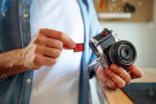 Preview: Man inserting memory card into digital camera