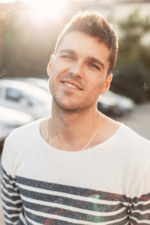 Preview: Handsome happy young man with a smile standing on sunset
