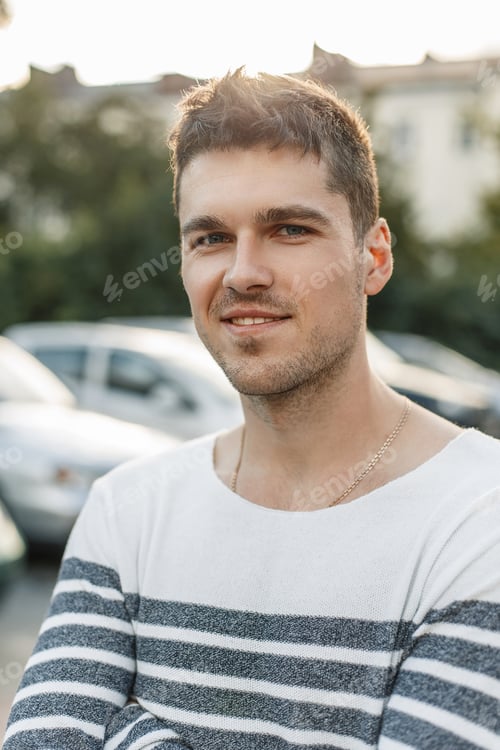 Preview: Portrait of a young handsome man with a smile. outdoors