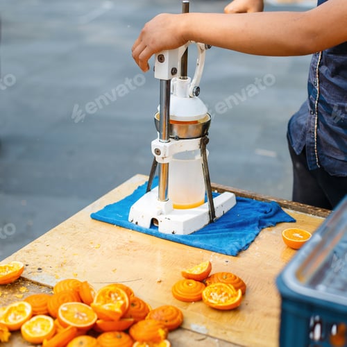 Preview: Young guy squeezes orange juice on the street.