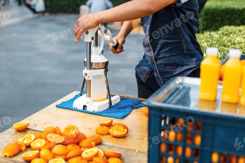 Preview: Man squeezes orange juice. Outdoors.