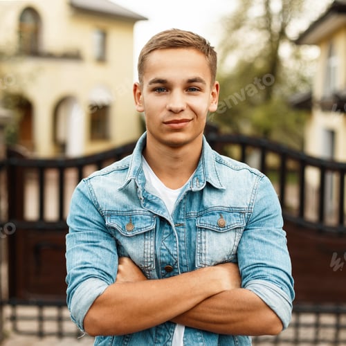 Preview: Portrait of a beautiful happy young man in a jeans jacket and a white T-shirt, outdoors