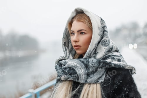 Preview: Beautiful young woman wearing a scarf in winter snowy day