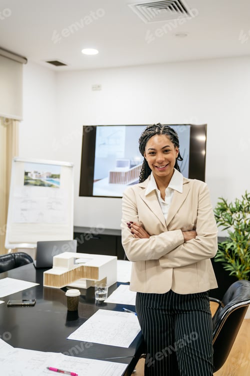 Preview: Real estate businesswoman presenting architectural model in meeting
