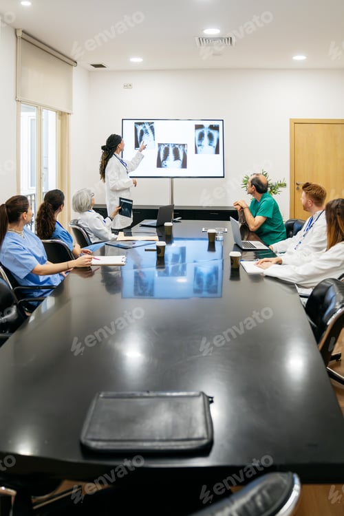 Preview: Medical team collaborating on x ray results during hospital meeting