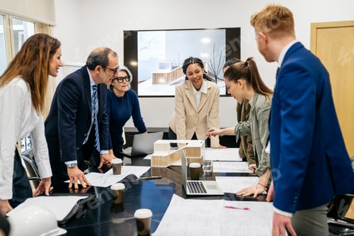 Preview: Real estate team discussing architectural model in office