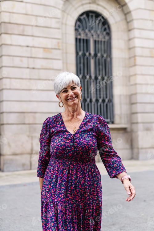 Preview: Joyful senior woman smiling in city setting