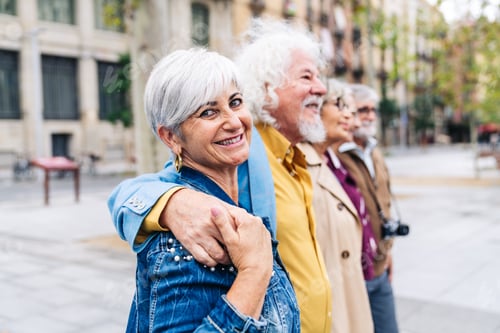 Preview: Happy seniors friends embracing walking city street
