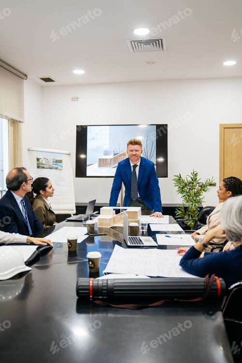Preview: Real estate investors discussing building model in office meeting
