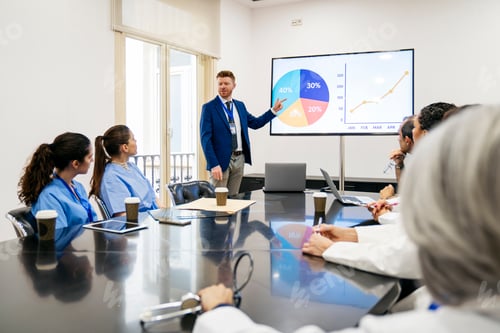 Preview: Healthcare team discussing medical data insights in hospital meeting