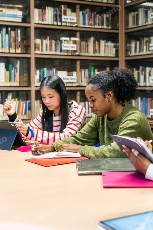Preview: Diverse students studying together in library researching