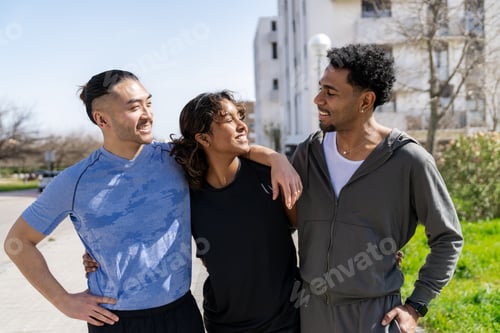 Preview: Diverse friends exercising outdoors, smiling and embracing teamwork