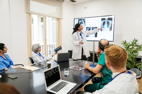 Preview: Medical team collaborating on radiology x rays in a hospital conference room