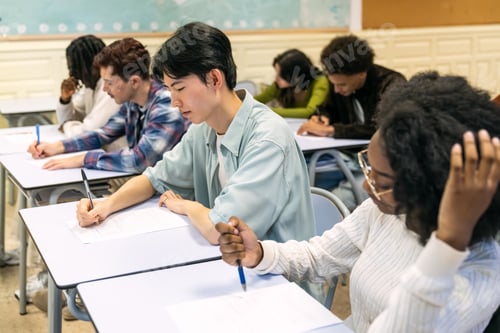 Preview: Diverse students taking exam in school classroom