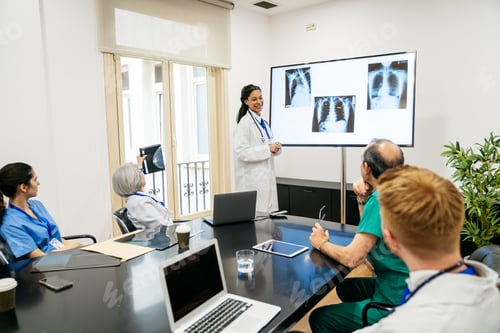 Preview: Medical team collaborating and discussing x ray results in a conference room