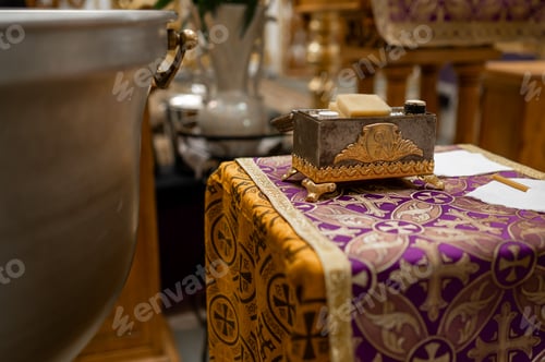 Preview: Orthodox chrismation kit box on altar table near baptism font inside church before ceremony