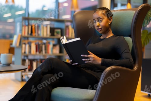 Preview: Student reading a book in library