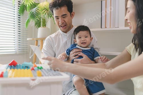 Preview: Happy young family playing with baby at home, parents engaging child with colorful toys and learning