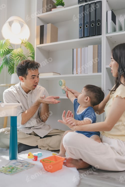 Preview: Young parents playing with baby using colorful toys at home, encouraging learning and motor skills,