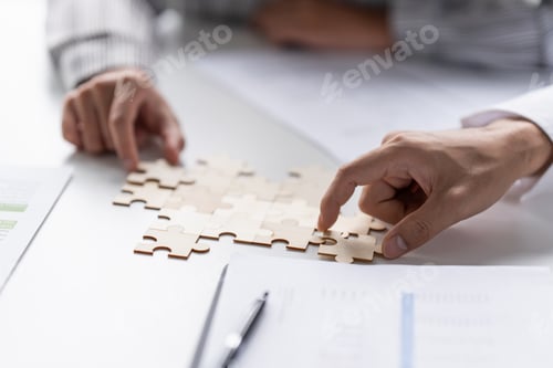 Preview: Businessman hands putting together puzzle pieces with Team Building join together and Business Colla