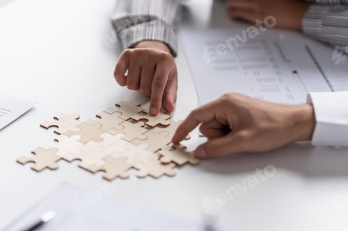 Preview: Businessman hands putting together puzzle pieces with Team Building join together and Business Colla