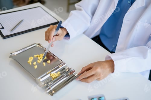 Preview: Pharmacist preparing medication counting pills for customer service in pharmacy
