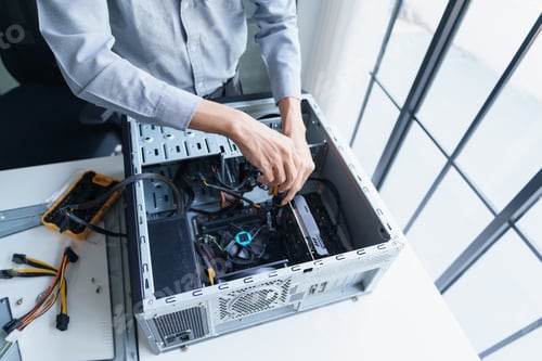 Preview: Asian IT support engineer using screwdriver fixing broken part in pc