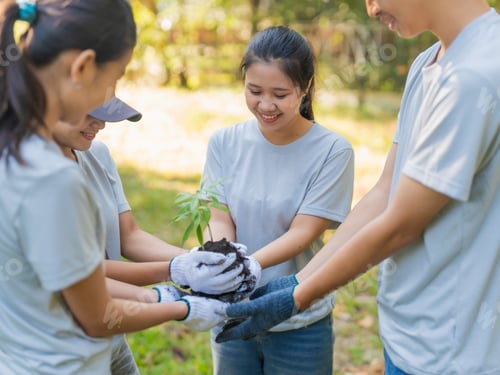 Preview: Group of Asian people holding seeding standing in a circle in forest