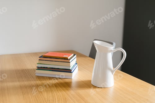 Preview: Books and jug on wooden table. Tranquility, home simplicity, and quiet balance of daily life. Copy s