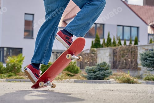 Preview: Teenager doing skateboard trick on residential street