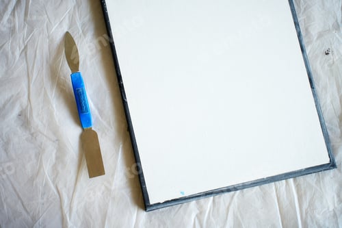 Preview: Blank canvas prepared with palette knife on protective sheet