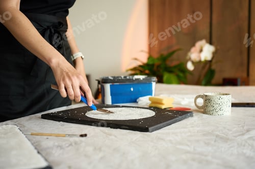 Preview: Woman making handmade wall decor on black canvas