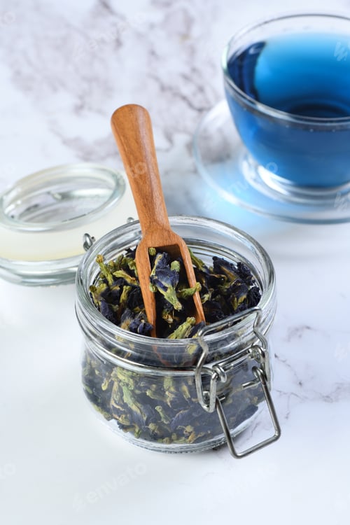 Preview: Blue butterfly pea tea in a glass jar and cup on marble background