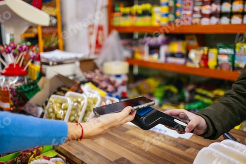 Preview: Customer using smartphone for contactless payment at grocery store
