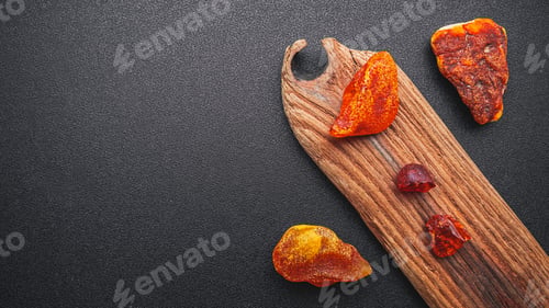 Preview: Natural amber. A piece of yellow transparent natural amber on a piece of textured wood