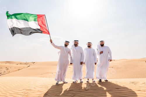 Preview: Group of middle-eastern men wearing traditional emiratis clothing and bonding in Dubai desert