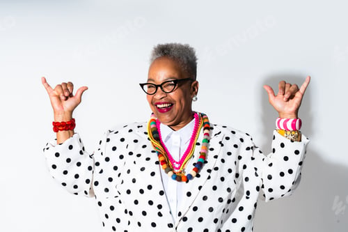 Preview: Joyful woman making shaka sign wearing colorful accessories