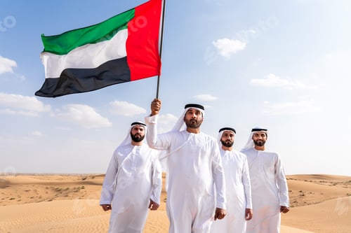Preview: Group of middle-eastern men wearing traditional emiratis clothing and bonding in Dubai desert
