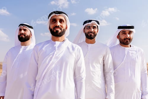 Preview: Group of middle-eastern men wearing traditional emiratis clothing and bonding in Dubai desert